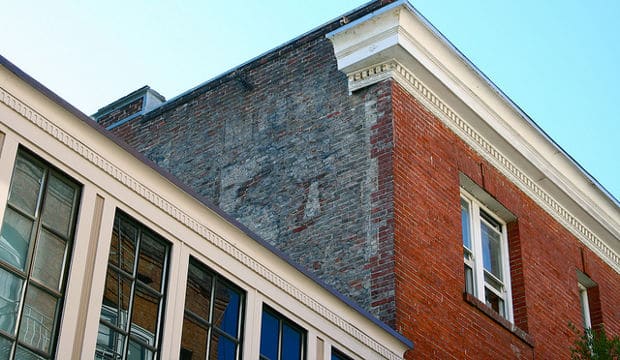 Corner of building showing portion of hand painted sign for Owl Cigars