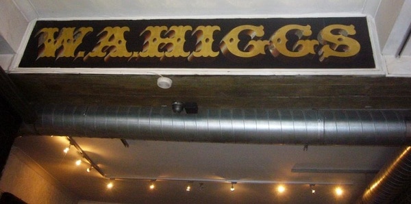 Reverse painted glass sign advertising W.A.Higgs