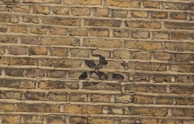 Fading ampersand, painted on brick