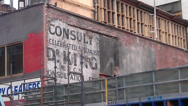 Fading sign painted on a wall advertising Dr King