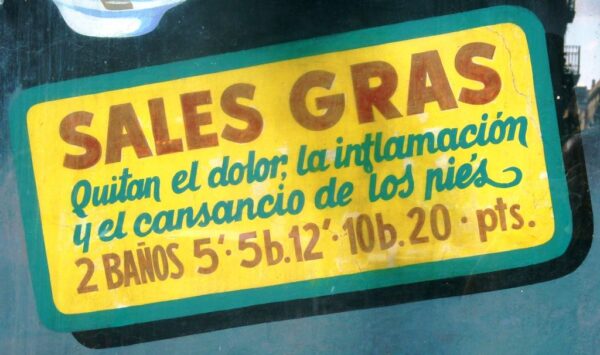 Detail of painted sign on a wall covered by perspex