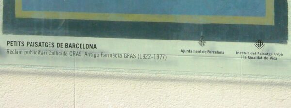 Detail of painted sign on a wall covered by perspex