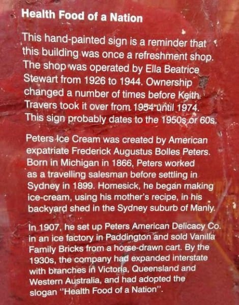 Painted sign on a wall covered by a perspex sheet