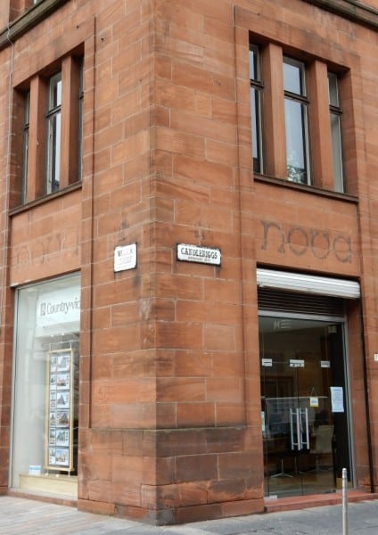 Two fading signs for Nova above a shop door
