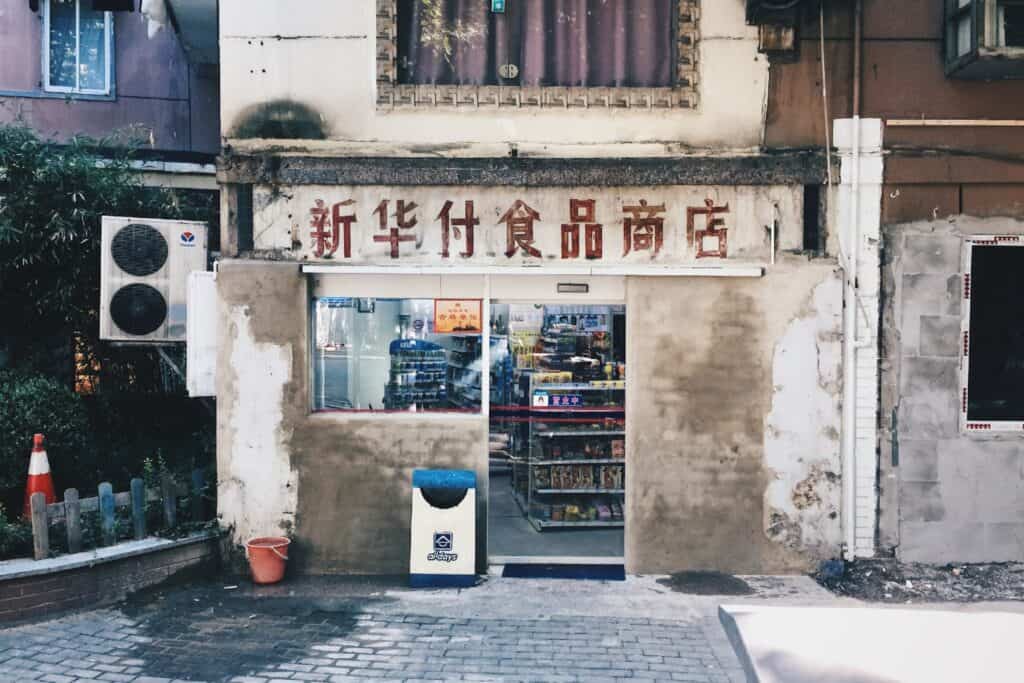 Fading painted shopfront with Chinese characters advertising a food shop.