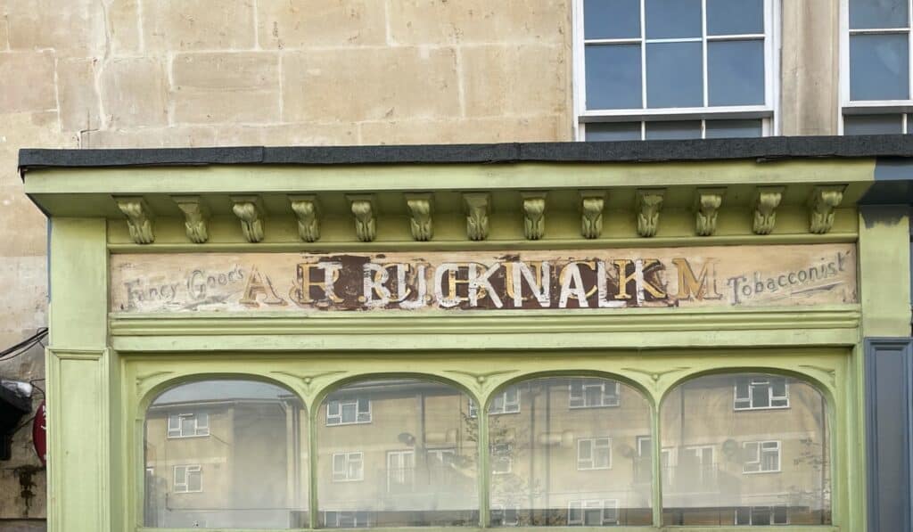 Shopfront with three layers of painted signs.